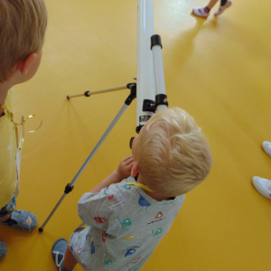 Kinder schaut durch Teleskop